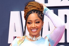 Brittish Williams smiling and wearing a colorful dress, posing with her hand on her hand