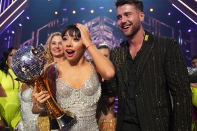 Xochitl Gomez on Dancing with the Stars reacting to being announed the winner, she's wearing a silver dress and holding the Mirrorball Trophy, standing next to Harry Jowsey who's wearing a black suit.