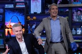 Andy Cohen standing next to Ryan Serhant who is sitting in a chair on Watch What Happens Live