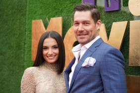 Craig Conover and Paige DeSorbo posing together at the 2022 MTV Movie and TV Awards. He's wearing a navy blue suit and she's wearing a gold dress; they're both smiling