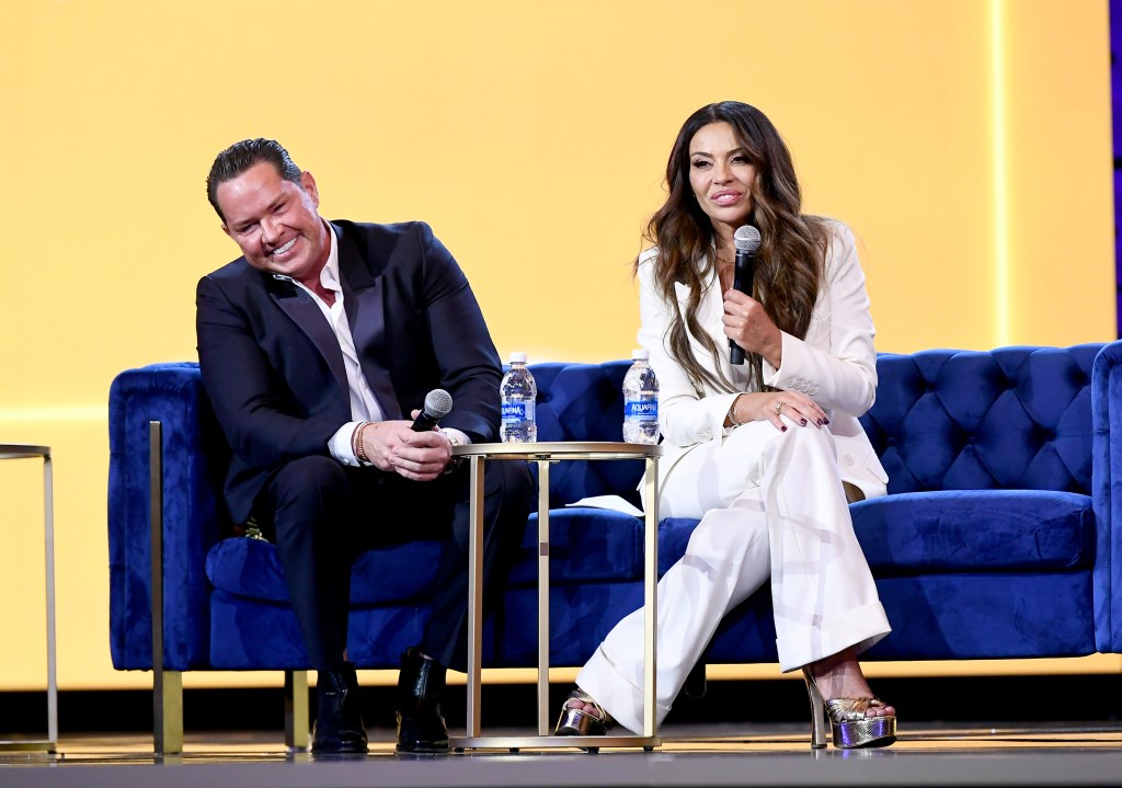 Paul Connel and Dolores Catania sitting together on a blue couch at BravoCon 2023