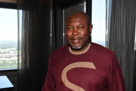 Simon Guobadia in a red shirt smiling at the camera