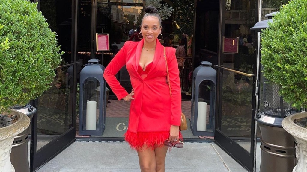 Dr. Mirica Sanders posing in a red dress with her hand on her hip