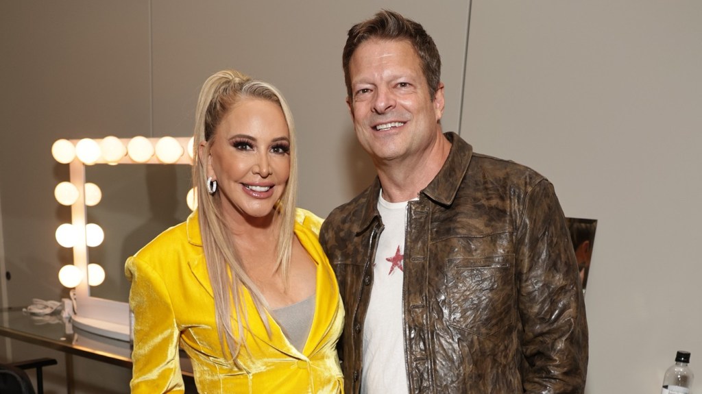 Shannon Beador posing in a yellow suit with John Janssen, the latter of which is now suing Shannon for fraud