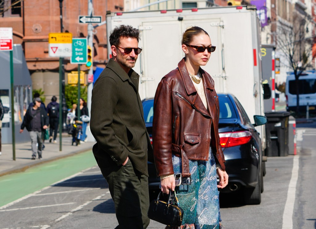 Gigi Hadid and Bradley Cooper walking through traffic in New York City