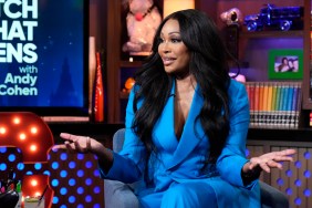 Cynthia Bailey in a blue suit holding her arms up in disbelief on Watch What Happens Live