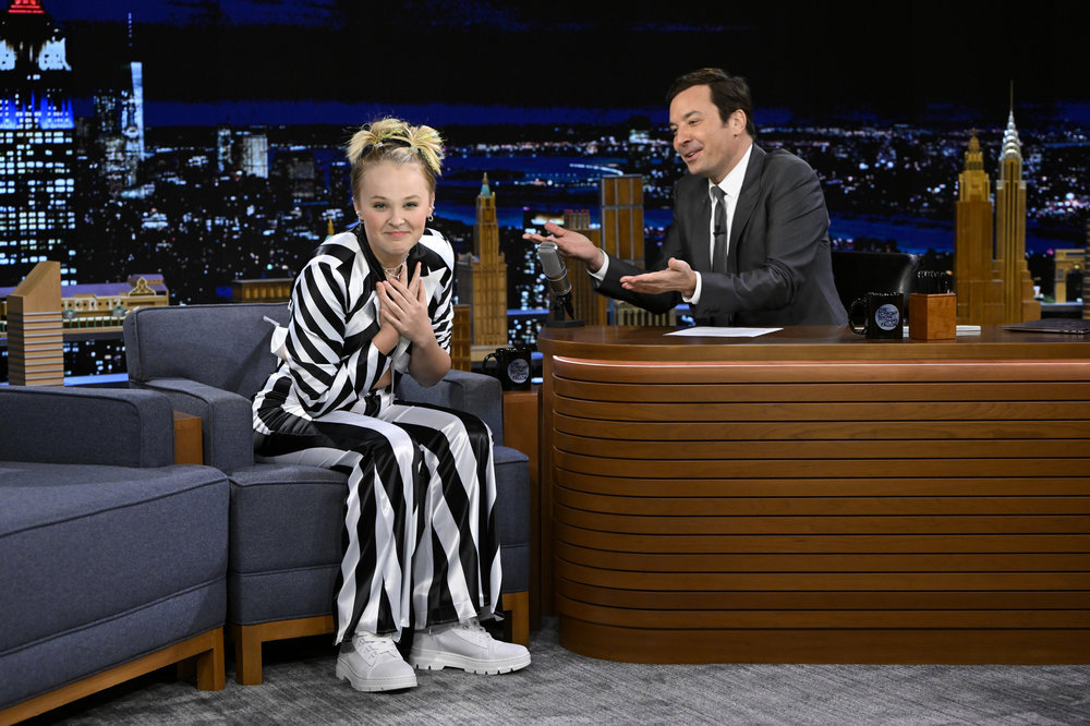 JoJo Siwa on The Tonight Show in a black and white striped suit 