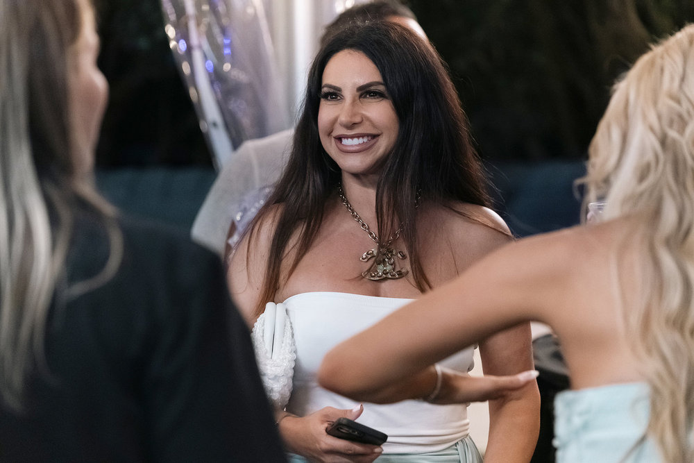 Jennifer Aydin filming RHONJ in a white dress.