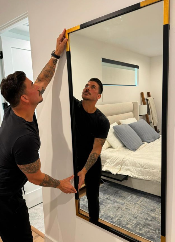 Jax Taylor hanging a mirror in his new home.