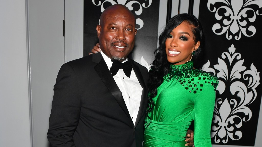 Porsha Williams in a green dress posing with Simon Guobadia