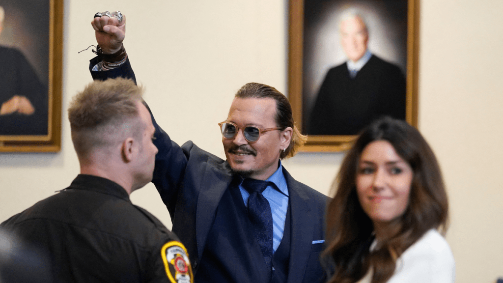 Actor Johnny Depp gestures to spectators in court after closing arguments at the Fairfax County Circuit Courthouse in Fairfax, Virginia, on May 27, 2022. - Actor Johnny Depp is suing ex-wife Amber Heard for libel after she wrote an op-ed piece in The Washington Post in 2018 referring to herself as a public figure representing domestic abuse.